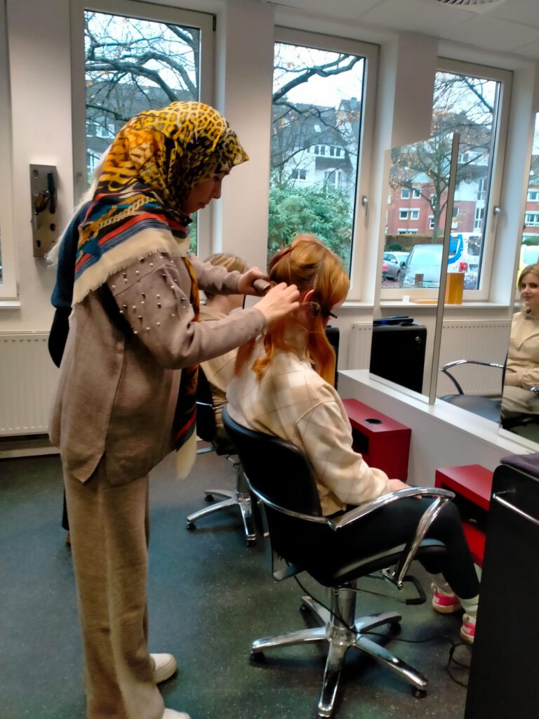 Im Friseursalon: Mädchen testet einen Lockenstab